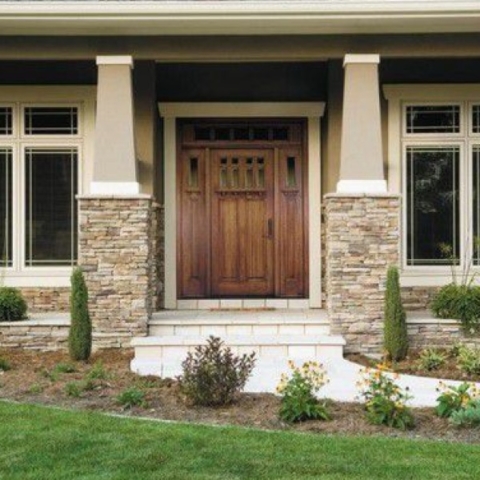 New wooden door with tilled stairs leading up in the front of a house