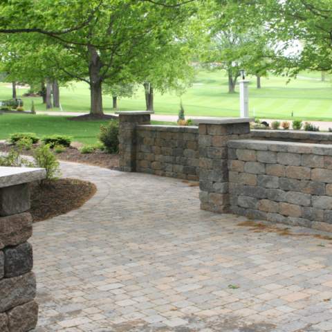Stone brick wall, and stone brick path going through a grass field